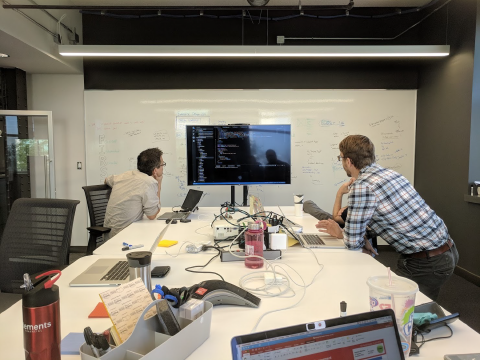 Picture of team members working together on code